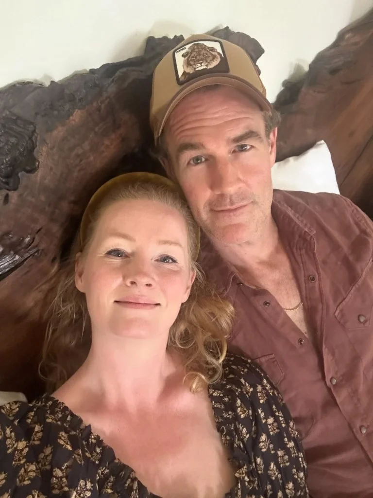 A woman with blond hair and a man wearing a baseball cap with a lion design pose for a selfie.