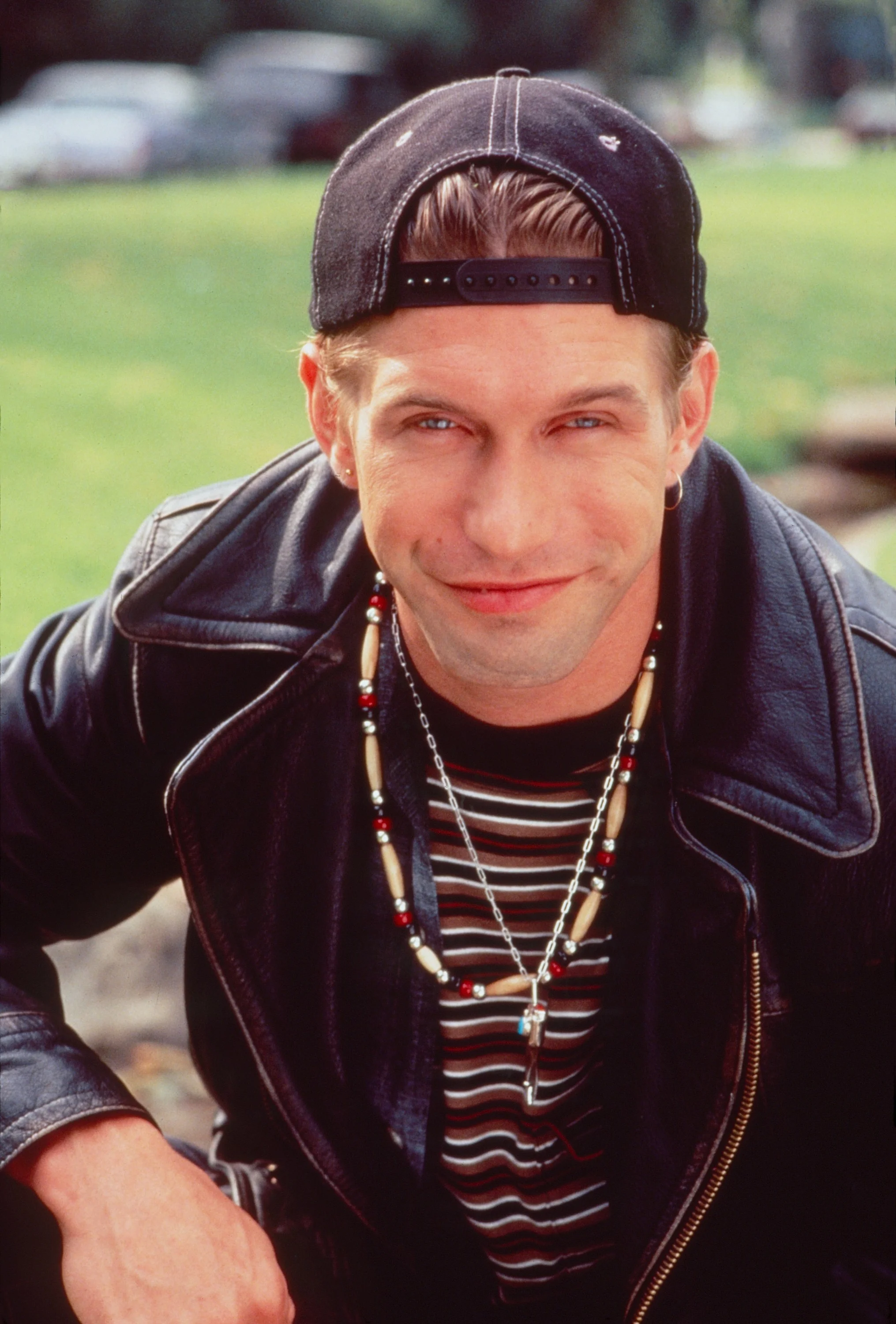 Stephen Baldwin in a black baseball cap, leather jacket, and striped shirt.