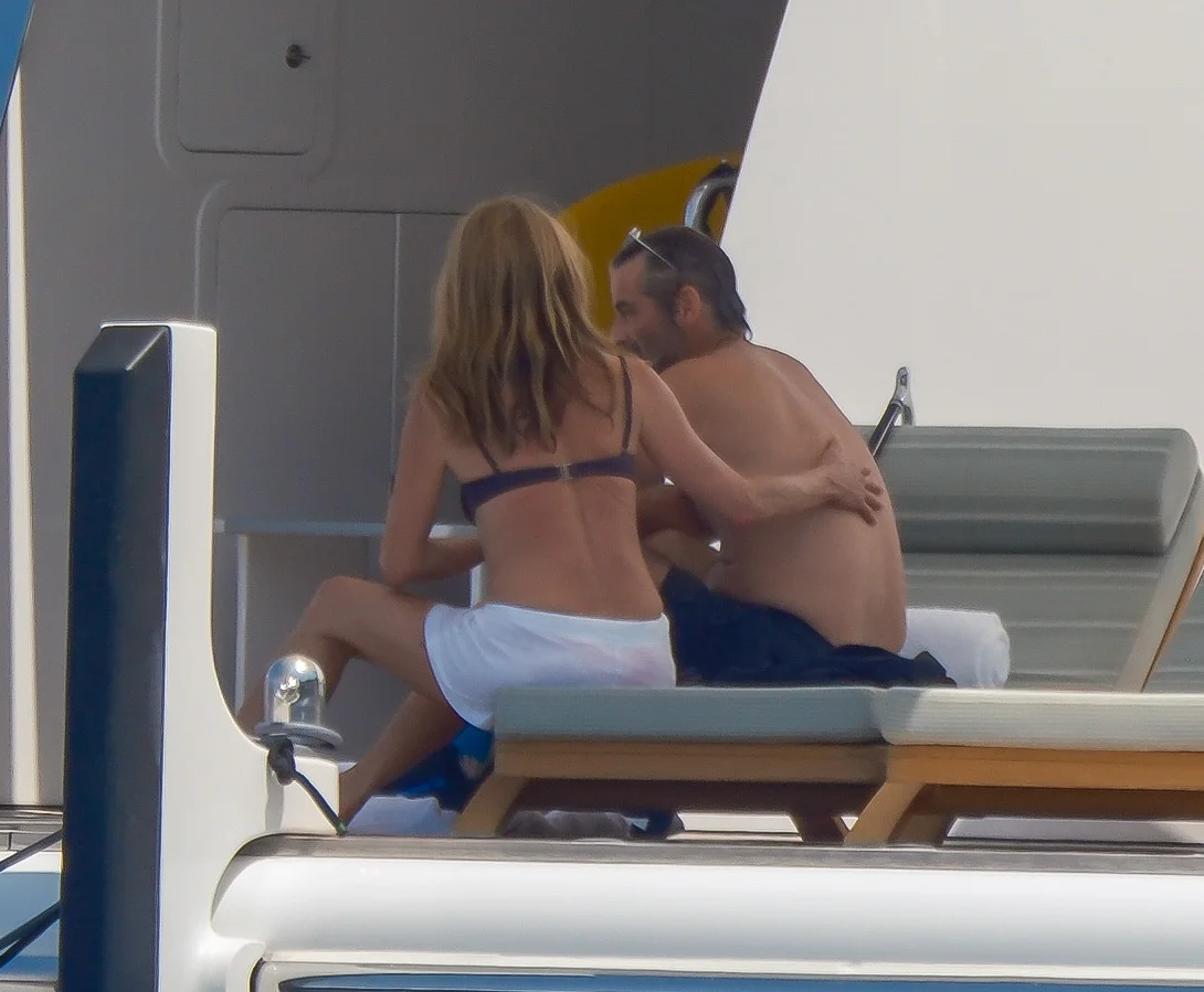 Jennifer Aniston and Jim Curtis embracing on a yacht.