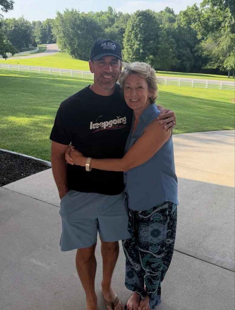 Aaron Rodgers with his arm around a woman.