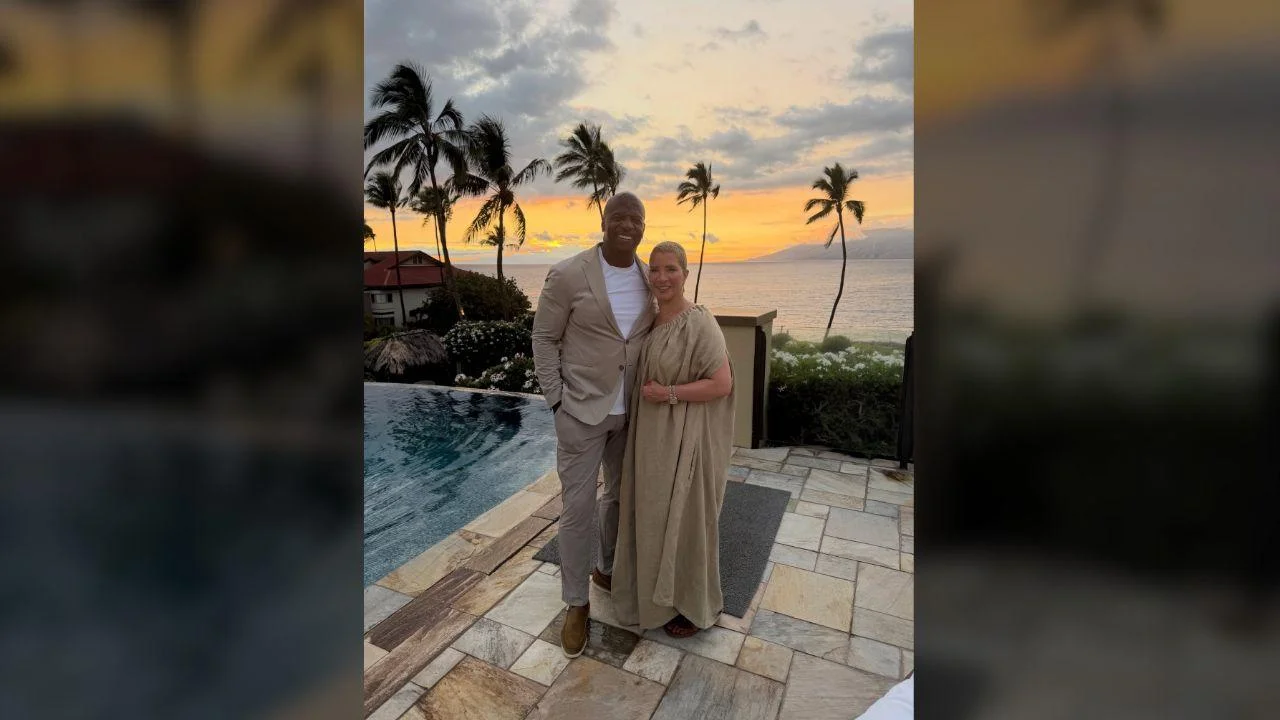 Photo of Terry Crews and Rebecca King-Crews posed in front of a gorgeous sunset.