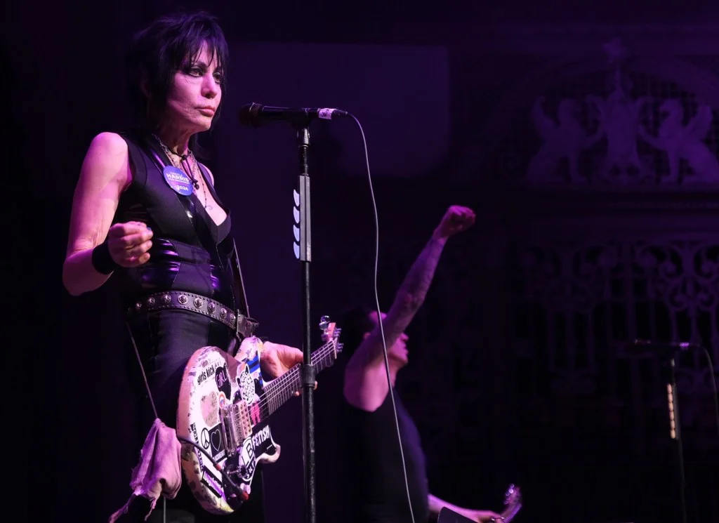 Joan Jett performing with her guitar on stage.
