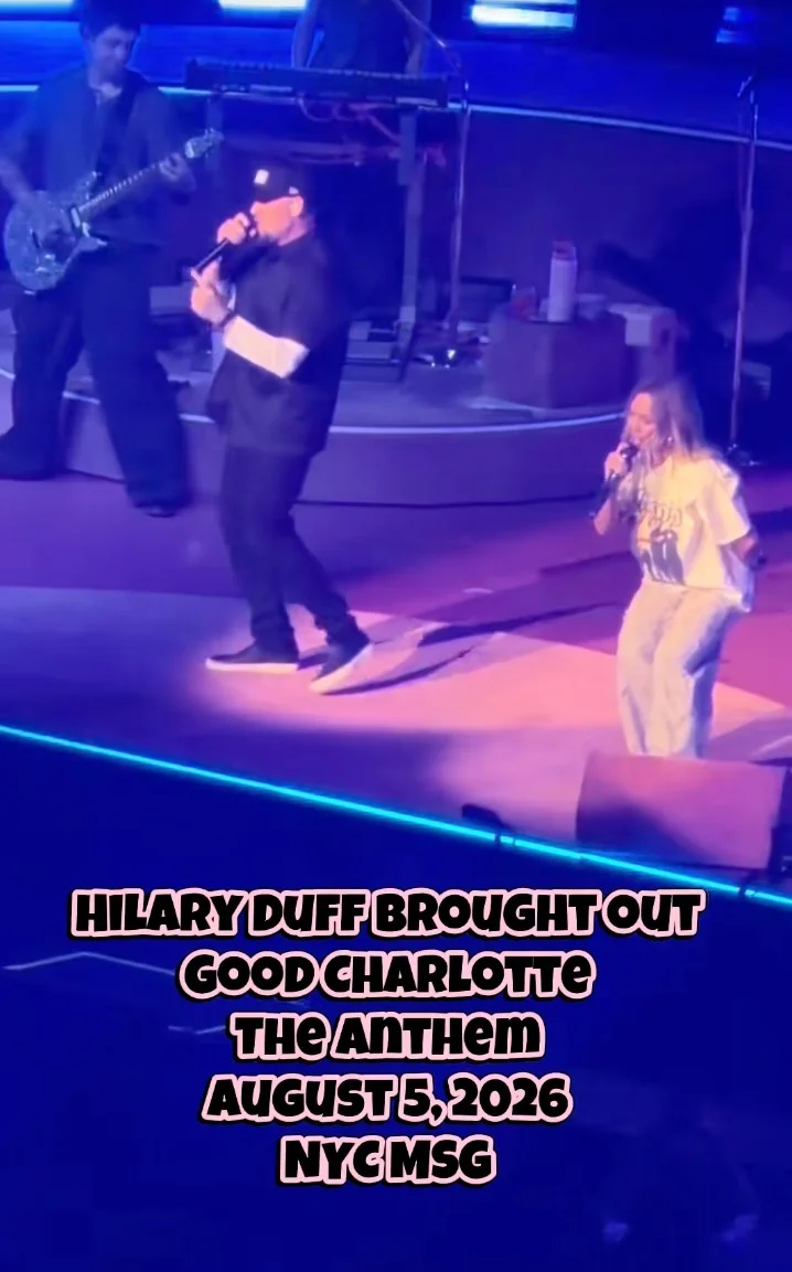 Hilary Duff performing on stage with Joel Madden and a guitarist.