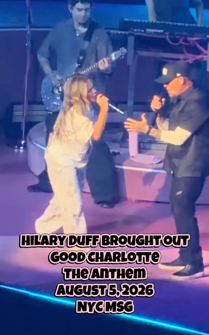 Hilary Duff and Joel Madden performing together on stage, with a guitarist in the background.