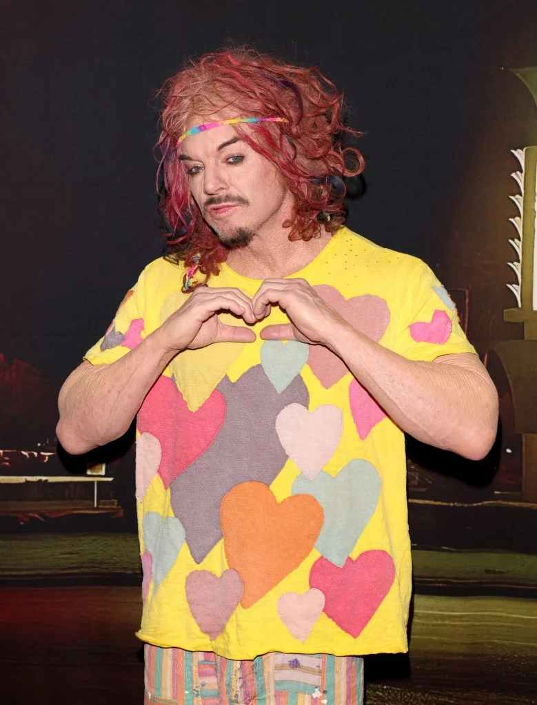 Carrot Top makes a heart shape with his hands.