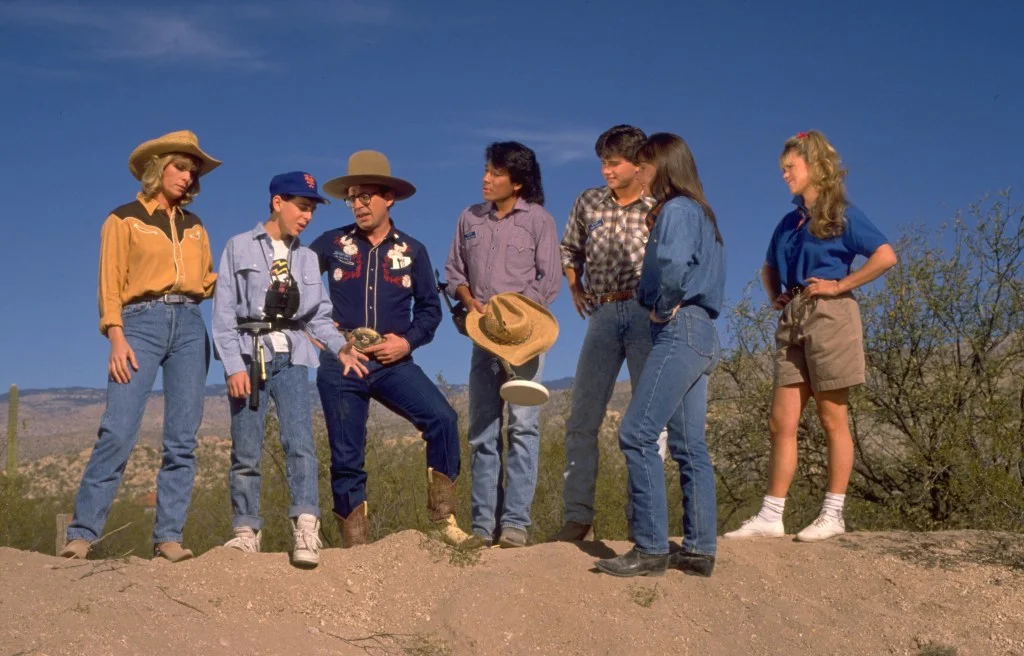 Lucy, Benjamin "Buddy" Ernst Jr., Mr. Benjamin Ernst, Danny Lightfoot, Tedd McGriff, and Melody Hanson standing in a desert landscape.