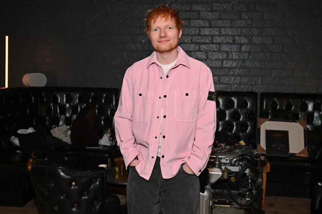 Ed Sheeran smiling at the camera at The Motoring Club.