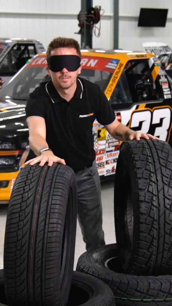 Blindfolded man identifying different tires by touch.