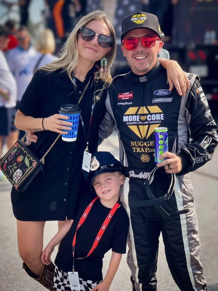Family posing at a racetrack.