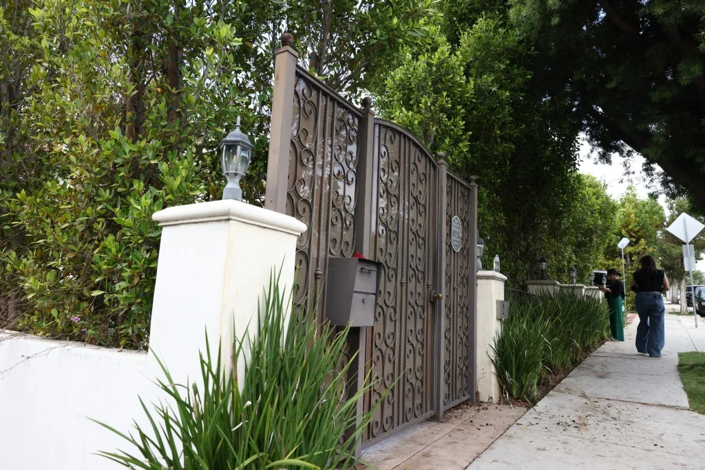 Residential living treatment facility in Santa Monica, CA, with a detailed gate, mailbox, and two people walking on a sidewalk.