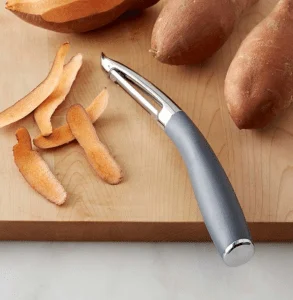 metal vegetable peeler with skin of sweet potato.